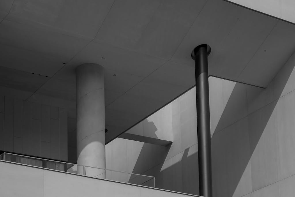 Home Abstract view of a modern architectural design featuring concrete pillars and dramatic shadows.